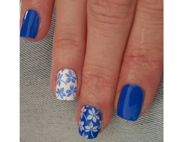Manicure blu, fiori bianchi e anulare con sfondi bianco