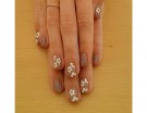Manicure taupe e fiori bianchi con applicazioni dorate