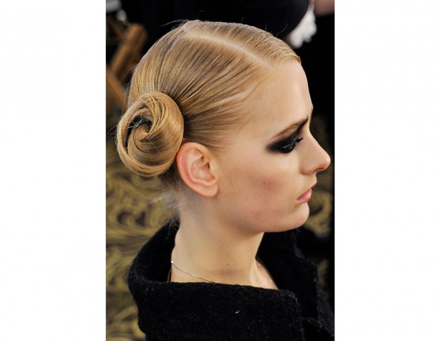 Lo chignon diventa originale se portato di lato. Da abbinare rigorosamente allo smokey eyes.