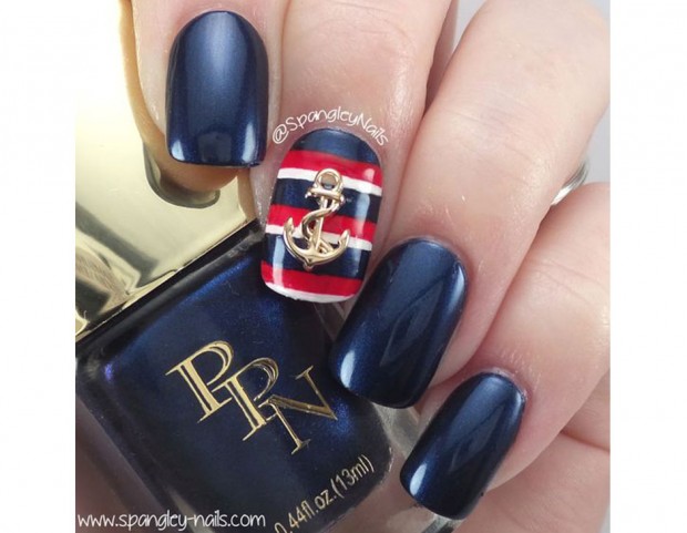 Base blu navy e accent nail a righe blu, bianche e rosse con charm a forma di ancora. (Photo credit: Pinterest @spangleynails)