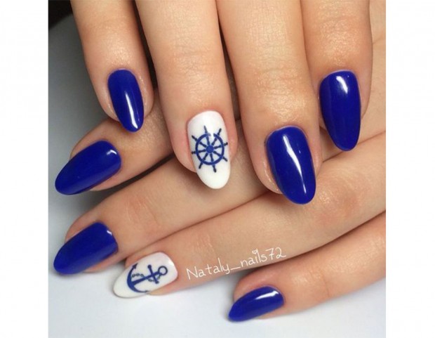 Nail art con base blu e accent nail bianca con decorazione. (Photo credit: Instagram @nataly_nails72)