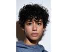 Capelli ricci corti, con un taglio che ne esalta il volume.