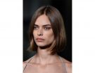 Capelli medi: caschetto liscio con riga centrale.
