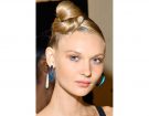 Top knot alto sulla nuca e radici tiratissime.