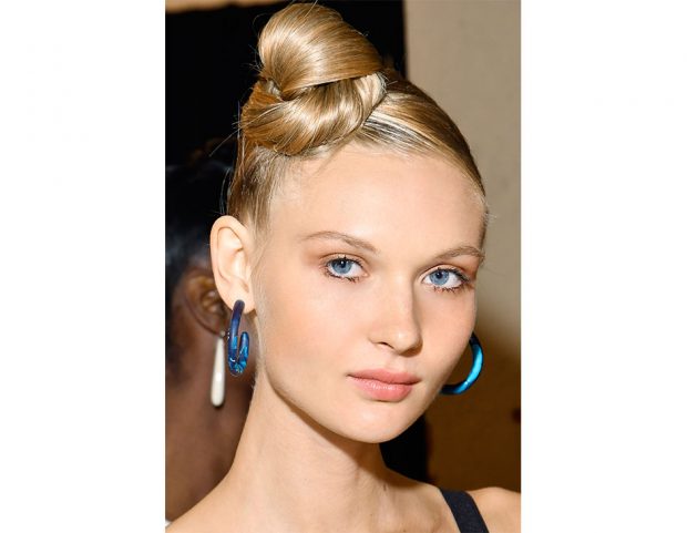 Top knot alto sulla nuca e radici tiratissime.