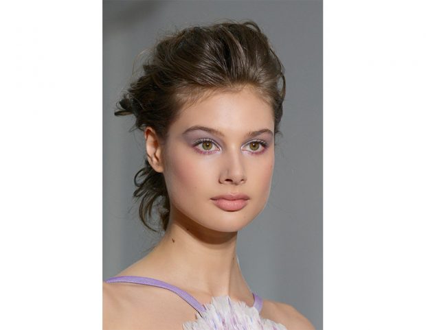 Capelli raccolti mossi con radici voluminose.