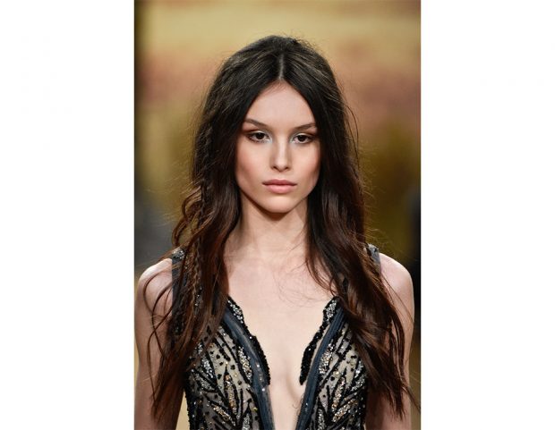 Capelli leggermente mossi con treccine laterali.