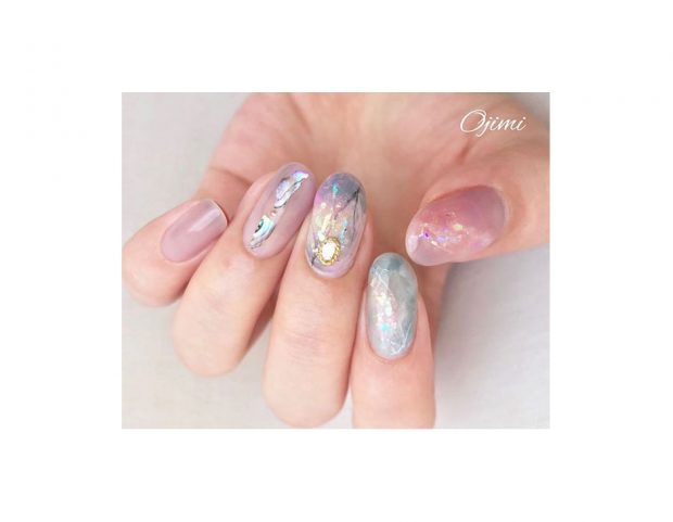 Cristalli e pietre preziose per questa manicure nei toni soft. (Photo credit: Instagram @ojimi_nail)