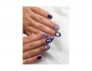 Nail art bianca e blu con righe, àncore e timoni. (Photo credit: instagram @jannikeivalje)