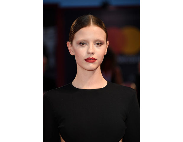 Raccolto super minimal e labbra intense color rosso scuro per Mia Goth. Photo credit: Getty Images