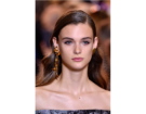 Capelli a onde con riga laterale e radici sleek.